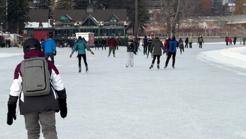 Several people can be seen skating on a stretch of the Rideau Canal Skateway in the afternoon.