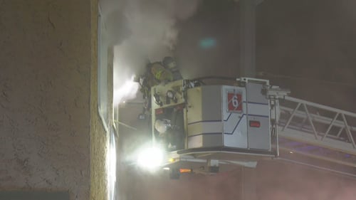 An Edmonton firefighter in a tower ladder bucket works at 10328 97 Ave. the morning of Feb. 23, 2026. (Evan Klippenstein / CTV News Edmonton)