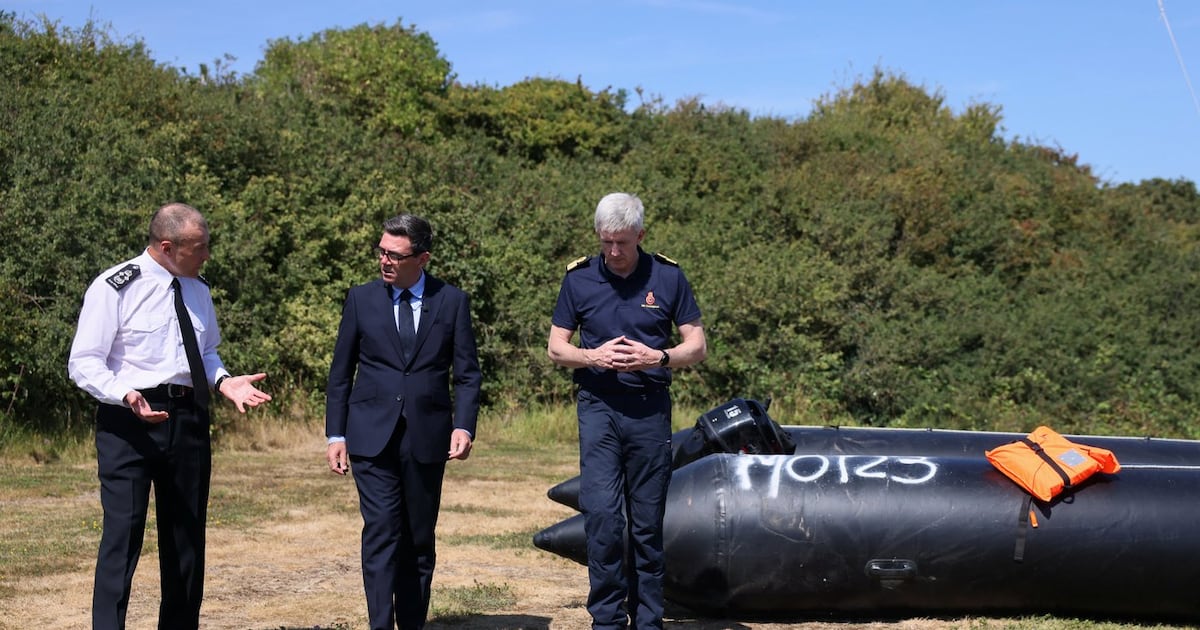 Britain's Prime Minister Andy Burnham, centre, speaks with John Craig, Interim Chief Coastguard, and Duncan Capps, Border Security Commander (DG BSC), left, near a recovered small boat, which was used by migrants crossing the English Channel, during a visit to HM Coastguard Maritime Rescue Coordination Centre, in Dover, Britain, Aug. 2, 2026. (Jack Taylor/Pool Photo via AP)