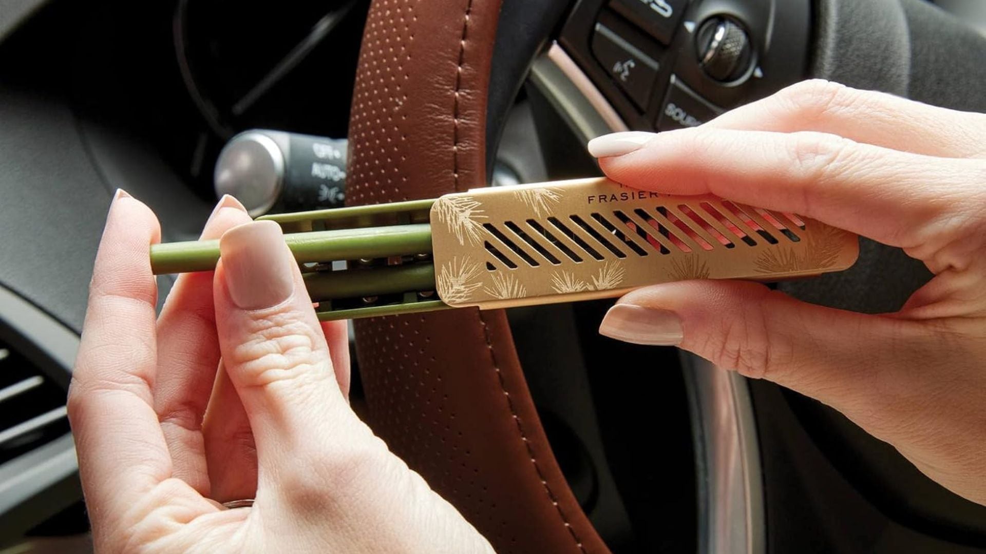 A person loading fragrance sticks into a Thymes Car Diffuser.
