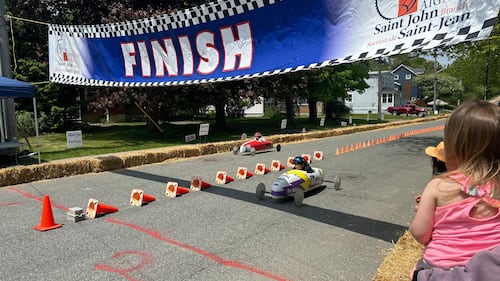 A blue finish line banner is pictured over a road.