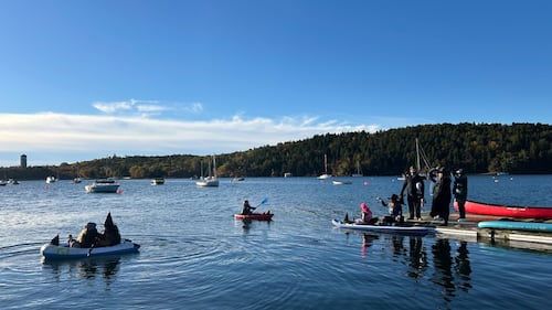 Paddlers dressed as witches are pictured on the water.