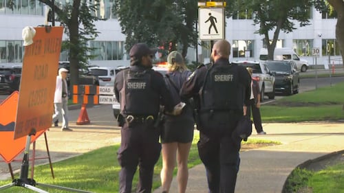 Alberta Sheriffs remove a woman who shouted at Premier Danielle Smith, " "You're a f****** fascist…. You sold us out to corporations," during the Kdays pancake breakfast at the legislature on July 16, 2026. (Sean McClune / CTV News Edmonton)