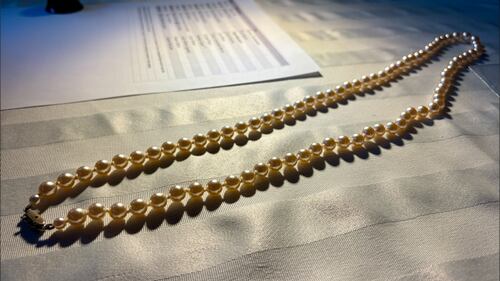 A pearl necklace is pictured.