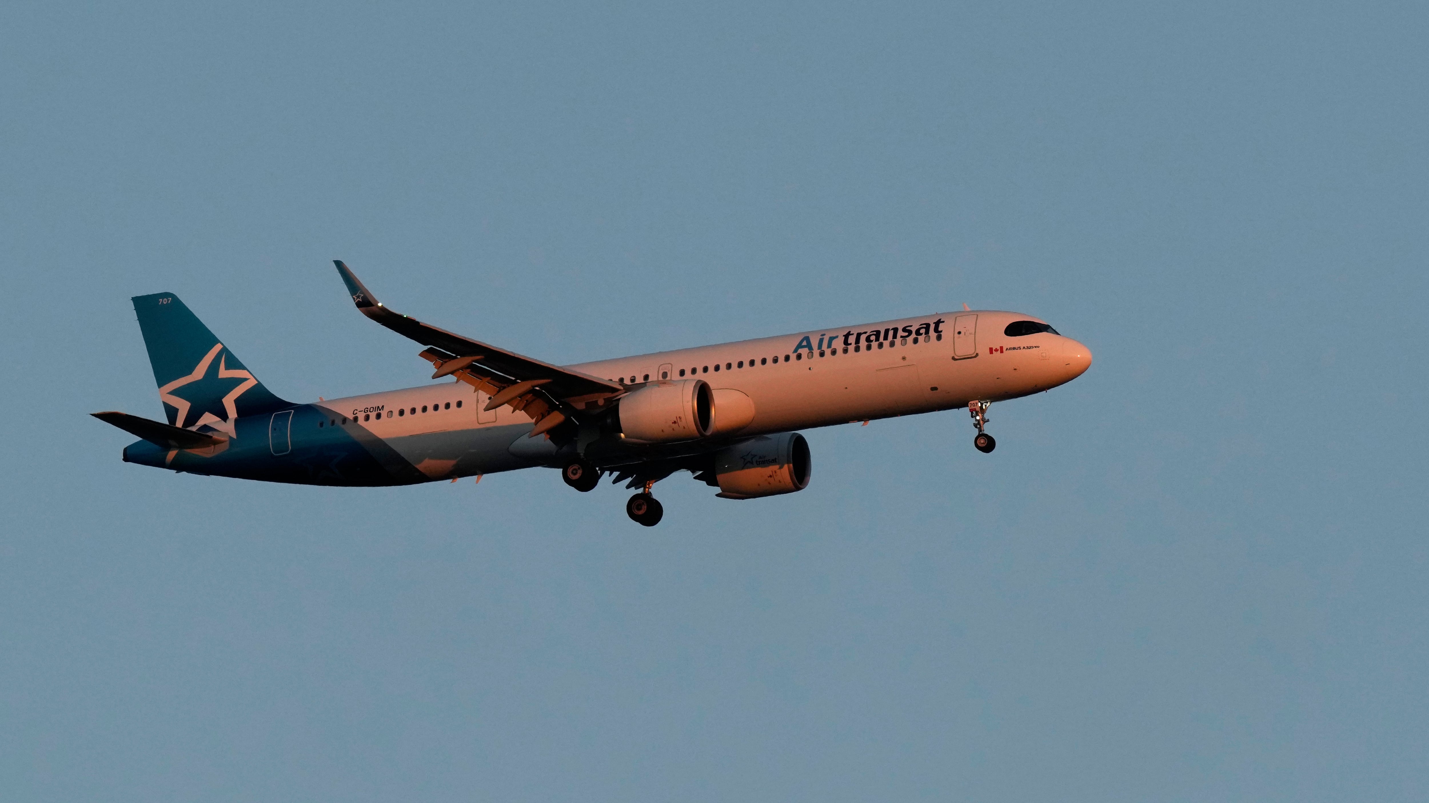 An Air Transat Airbus A321neo approaches for landing in Lisbon at sunrise, Sunday, June 23, 2024. (AP Photo/Armando Franca)