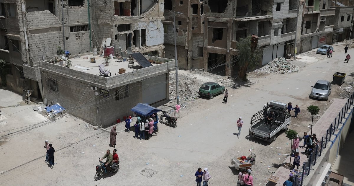 Daily life continues among damaged buildings, some under reconstruction, in the Yarmouk Palestinian refugee camp, devastated by years of fighting and displacement during the Syrian war, in Damascus, Syria, Tuesday, May 19, 2026. (AP Photo/Ghaith Alsayed)