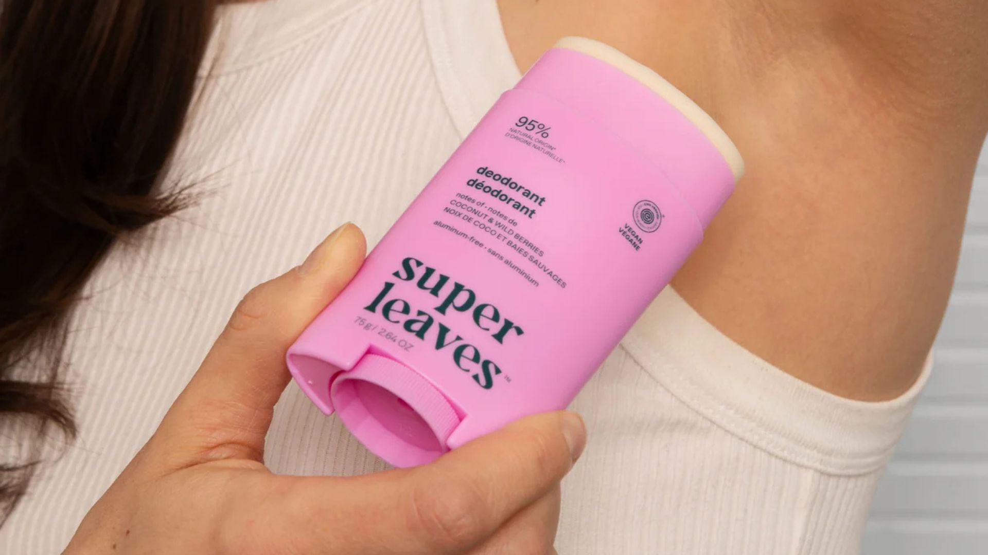 A person applying ATTITUDE Deodorant.