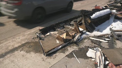 A vehicle on Stony Plain Road drives inches from debris from the Jasper Place Hotel on April 1, 2026. (Galen McDougall/CTV News Edmonton)