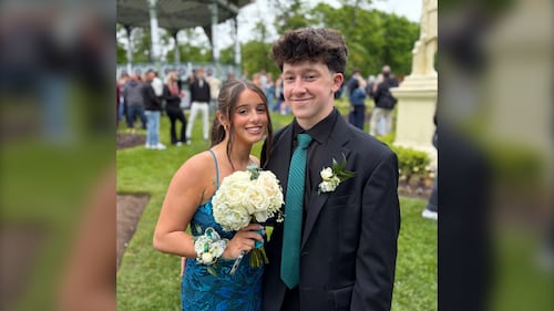 Two high school students pose together for prom.