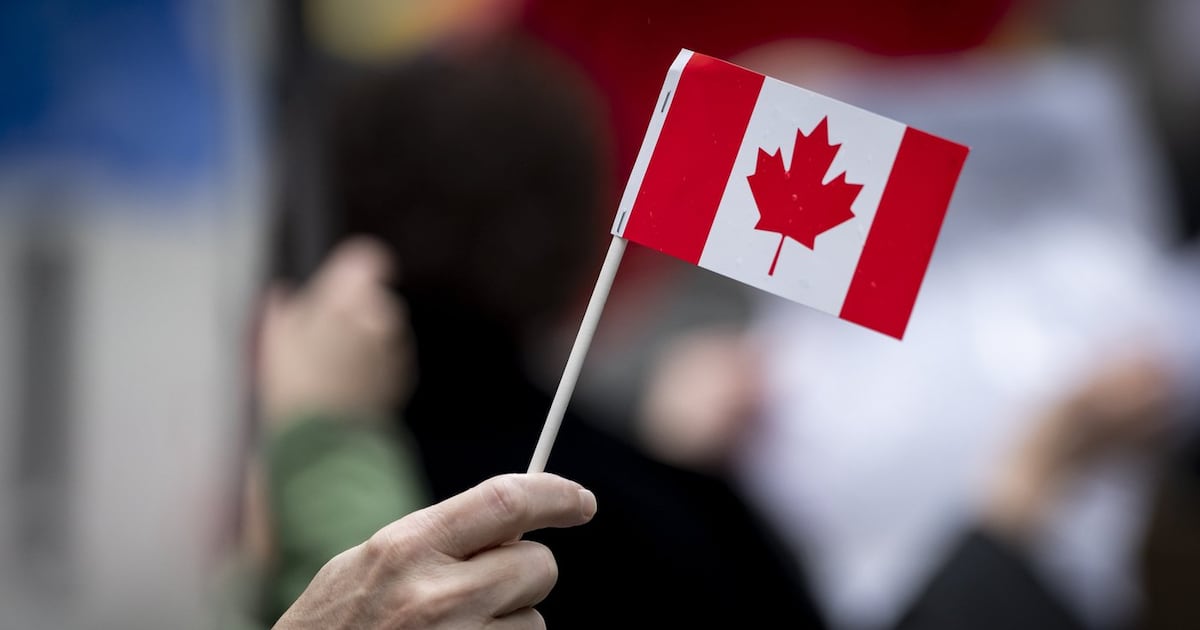 A person waves a small Canadian flag during a protest against U.S. President Donald Trump's tariffs in Vancouver, B.C., on Tuesday, March 4, 2025. THE CANADIAN PRESS/Ethan Cairns