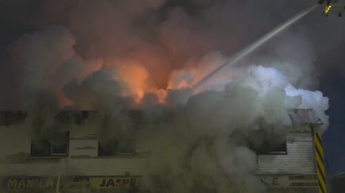 Firefighters on ladder trucks spray water on a fire at the former Jasper Place Hotel along Stony Plain Road in Edmonton the early morning of Feb. 19, 2026. (Sean McClune / CTV News Edmonton)