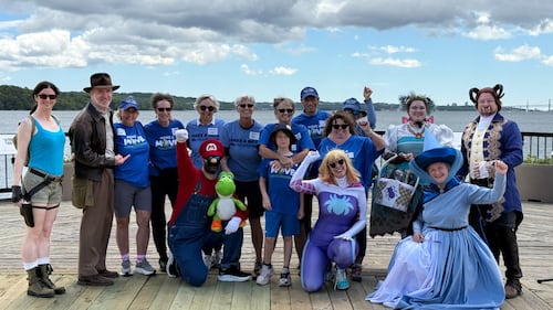 A group of people pose for a photo on a boardwalk.