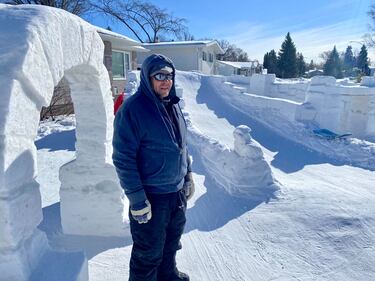 Howard Queau poses with snow sculptures build on Cabot Crescent on Feb. 19, 2025. (Jamie Dowsett/CTV News Winnipeg)