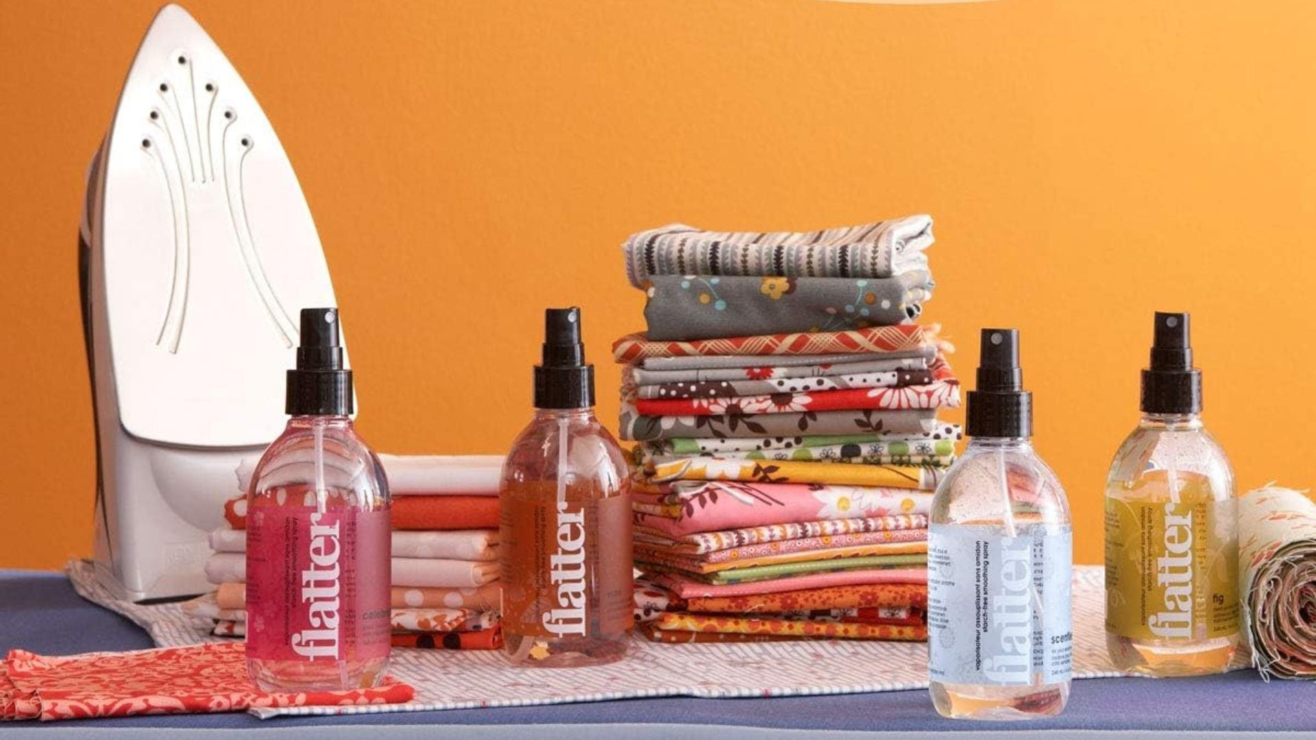 a bunch of wrinkle sprays with a pile of laundry and an iron