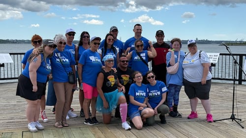 A group of people pose for a photo on a boardwalk.