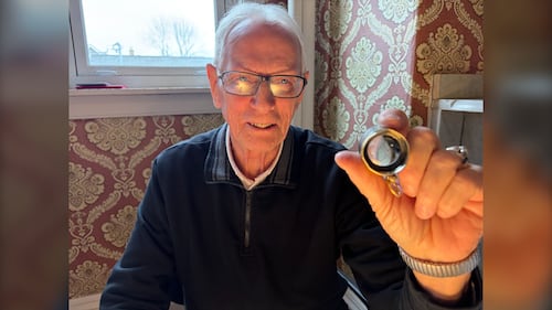 A man holding a magnifying glass is pictured.