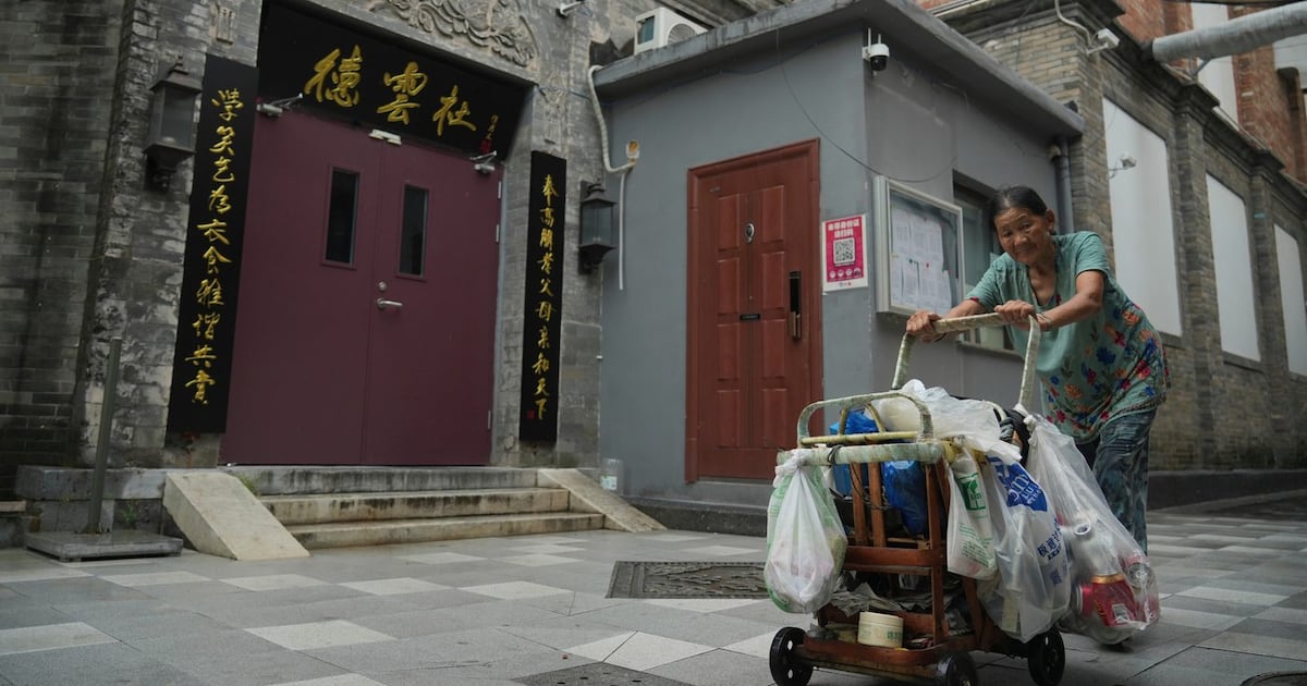Photo: ctvnews.ca A woman pushes a cart past a Deyunshe theatre, part of the comedy group founded by Guo Degang, in Beijing, Saturday, Aug