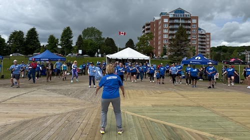A group of people participate in an aerobic warm up.