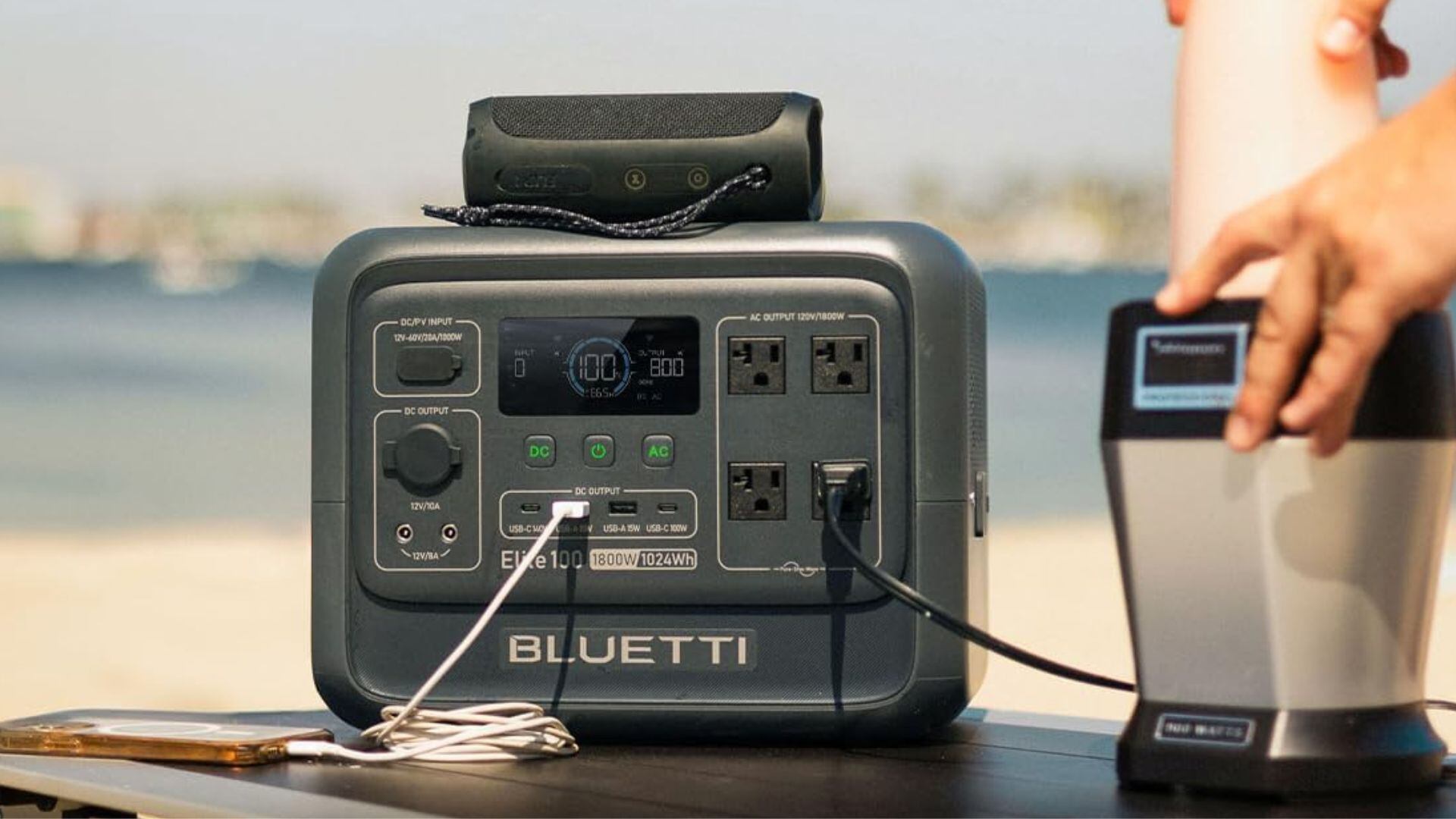 A power station is being used to power a blender at a beach.