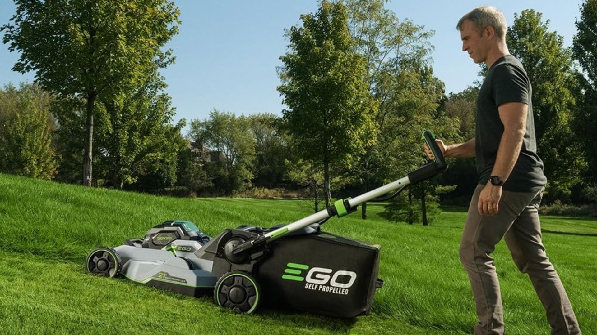 A person pushing an EGO lawn mower across a lawn.