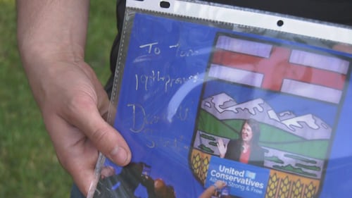 Tom Johnson shows the autograph her received from Alberta Premier Danielle Smith during the KDays pancake breakfast at the legislature on July 16, 2026. (Sean McClune / CTV News Edmonton)