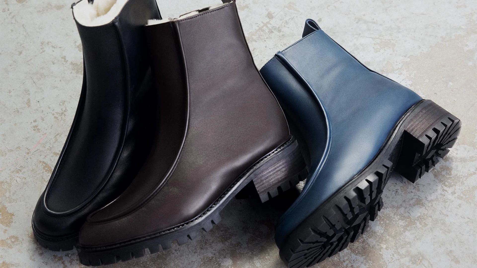 Three Maguire boots in different colours on a concrete floor.