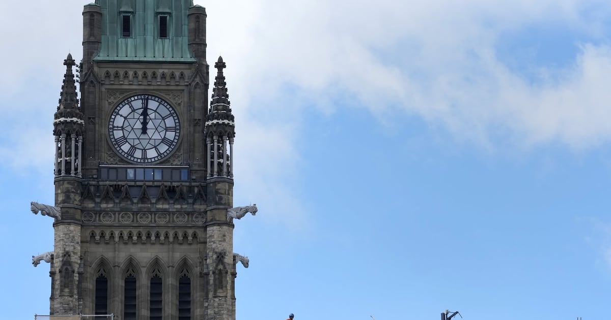 A worker stands on top of the Centre Block buildings below the Peace Tower on Parliament Hill in Ottawa on Tuesday, Sept. 8, 2026. THE CANADIAN PRESS/Adrian Wyld