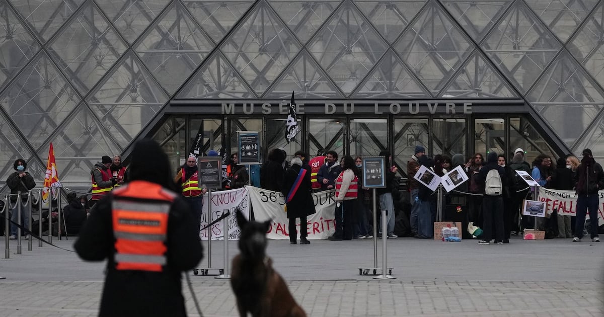 Workers block the entrance of the Louvre museum during a protests against rising living costs, in Paris, Monday, Oct. 19, 2026. (AP Photo/Christophe Ena)