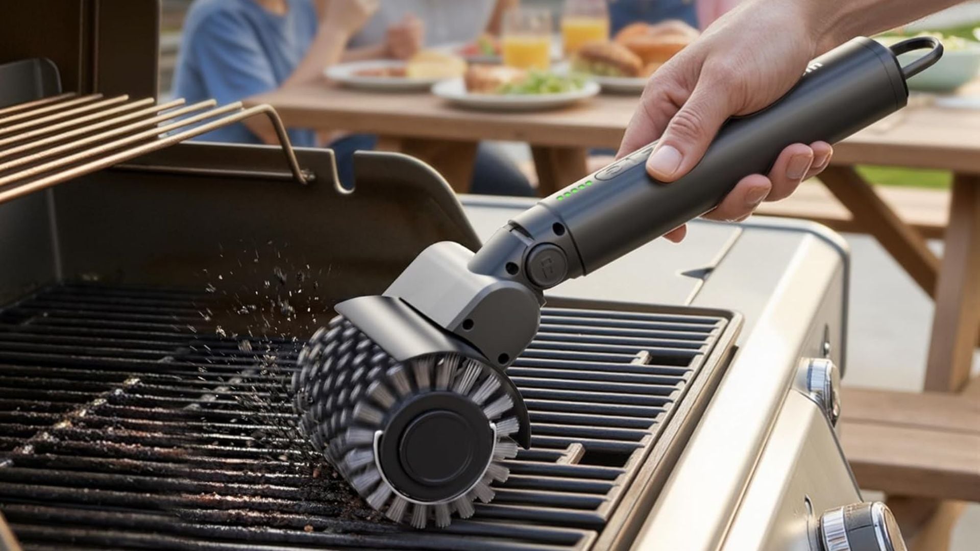 A person using an electric brush to clean their grill.