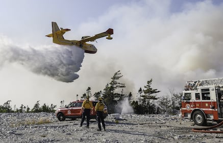 Department of Natural Resources firefighters watch a water bomber make a pass over a wildfire in the Bayers Lake area of Halifax. (Source: Province of Nova Scotia)