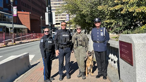 Officers are pictured with a dog.