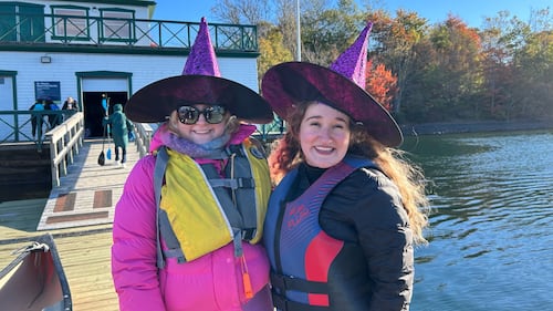 Two women pose for a photo while dressed up as witches.
