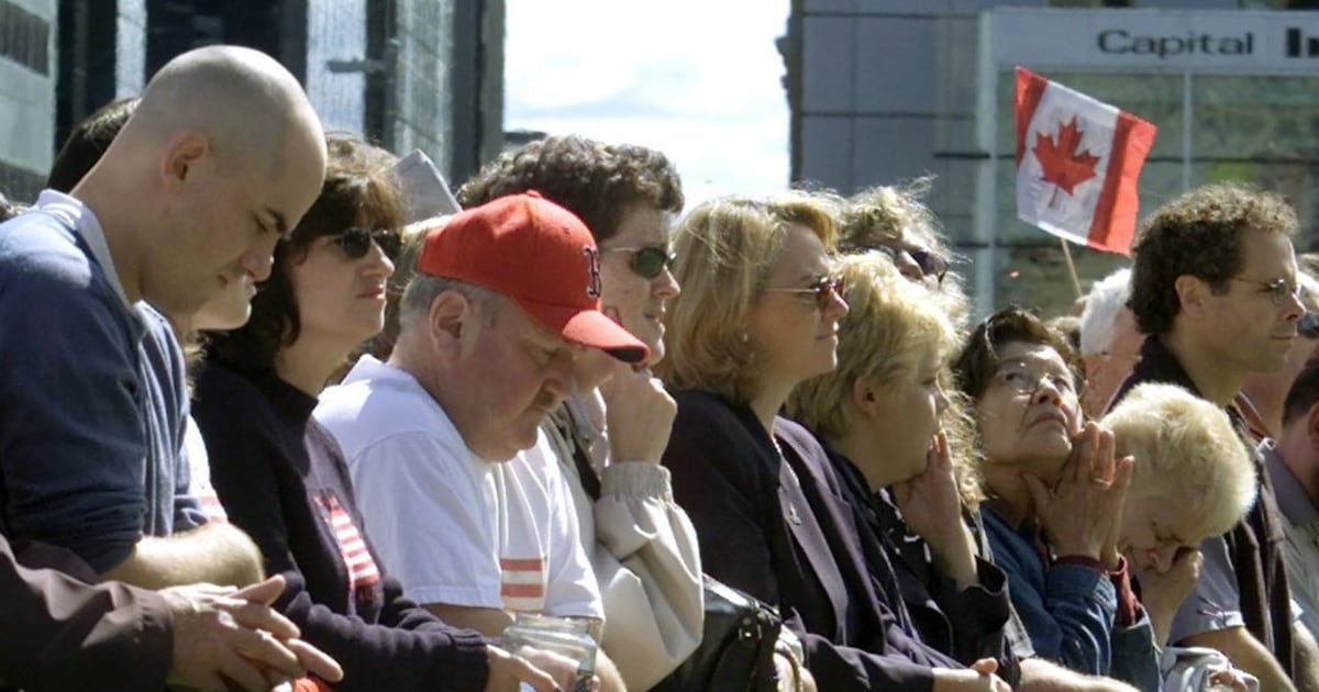 People bow their heads for three minutes of silence at a memorial ceremony in Ottawa Friday Sept 14, 2001, for the victims of Tuesday's terrorist attacks on the United States.(CP PHOTO/Tom Hanson)