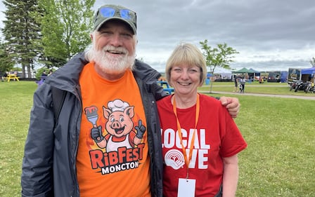 A man in an orange shirt and woman in a red shirt are pictured.