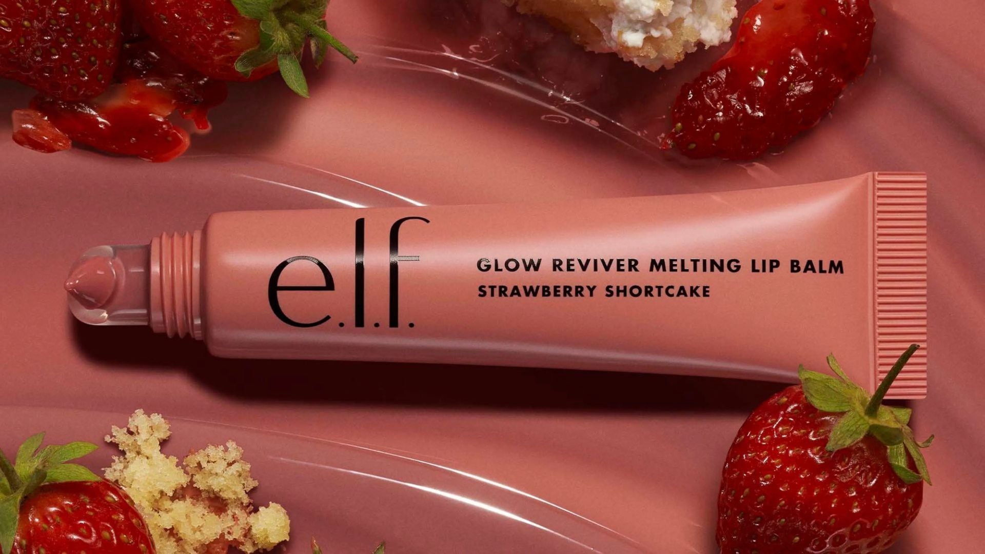 a lip gloss tube surrounded by strawberries