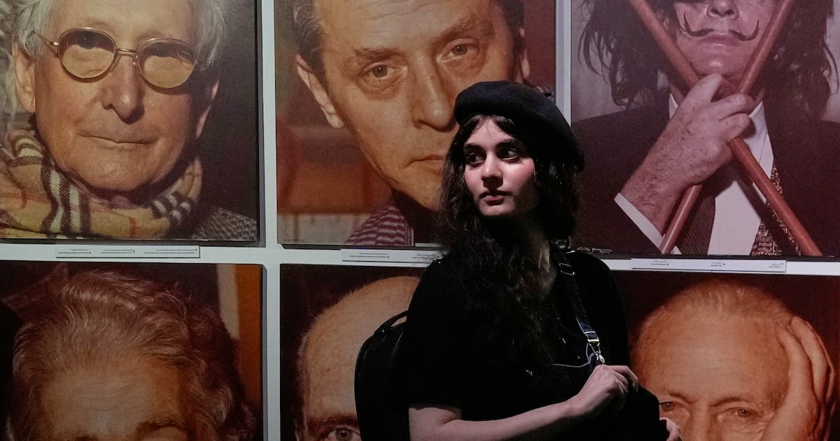 A woman visits a photography exhibition showcasing works by world photographers from the collection of the Tehran Museum of Contemporary Art, in Tehran, Iran, Saturday, Aug. 22, 2026. (AP Photo/Vahid Salemi)