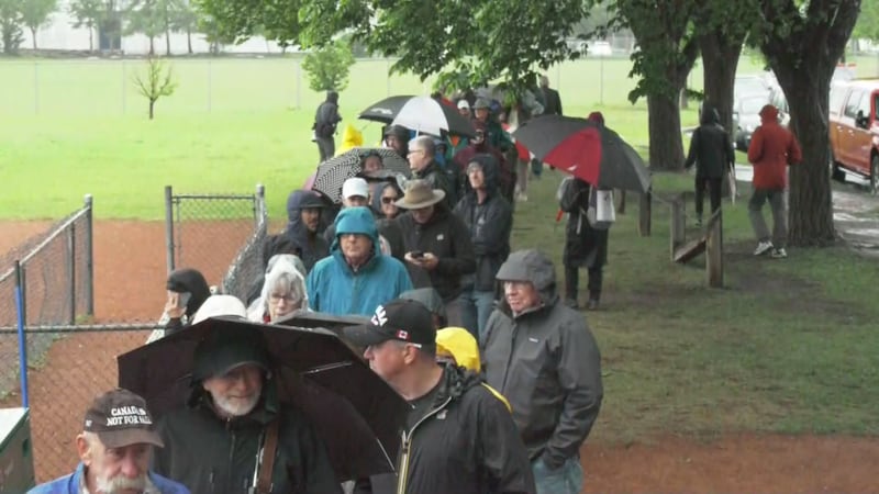 Hundreds of Calgarians brave rain to pick up Forever Canadian lawn sign