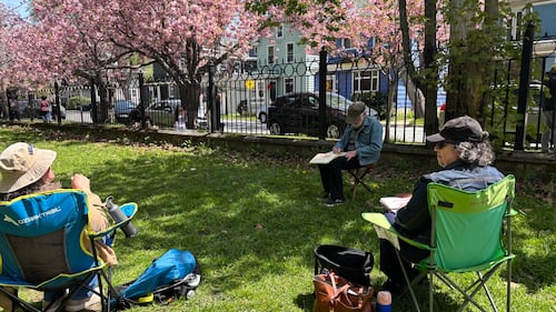 A group of artists paint photos of cherry blossoms.