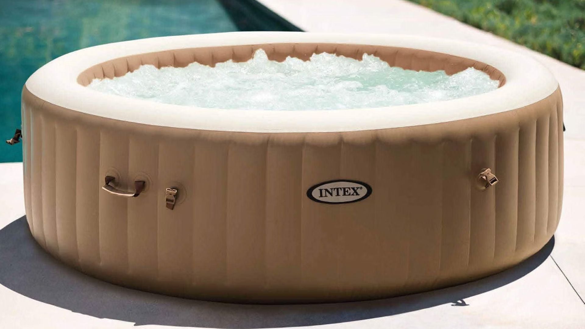 An Intex inflatable hot tub beside a pool.