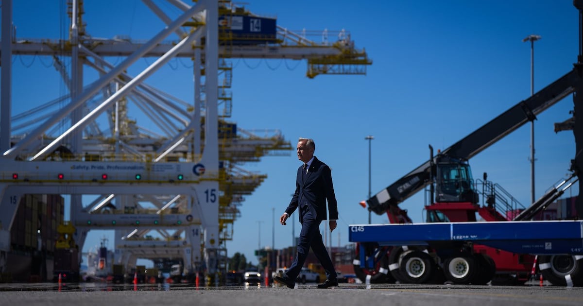 Prime Minister Mark Carney walks to give a statement after touring Global Container Terminals' Deltaport facility, at Roberts Bank in Delta, B.C., on Thursday, July 30, 2026. THE CANADIAN PRESS/Darryl Dyck