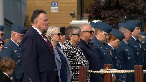 A crowd is pictured bowing their heads.