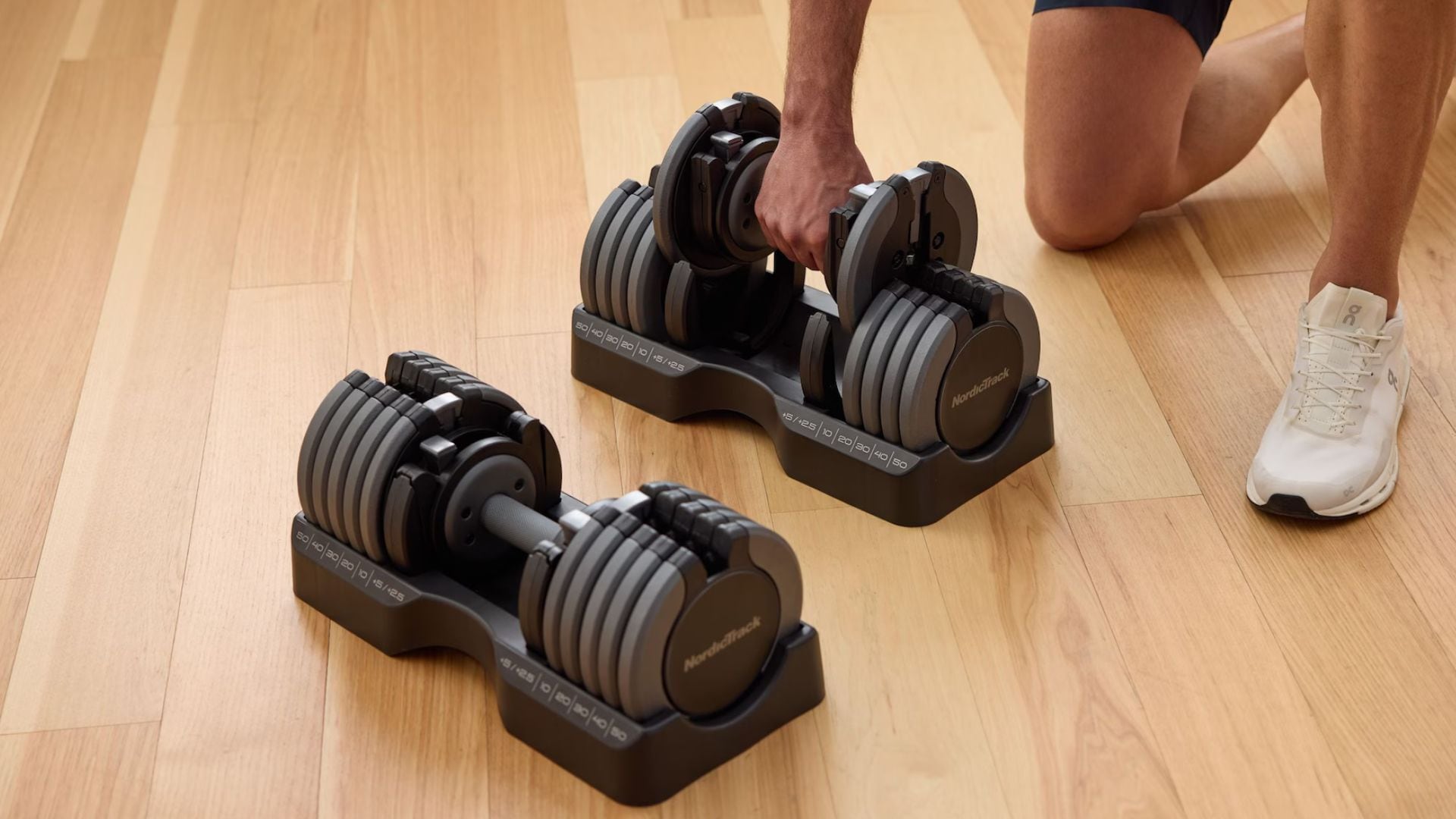 a person lifting a dumbbell on a wooden gym floor