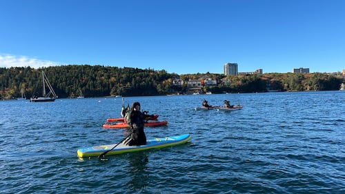 Paddlers dressed as witches are pictured on the water.