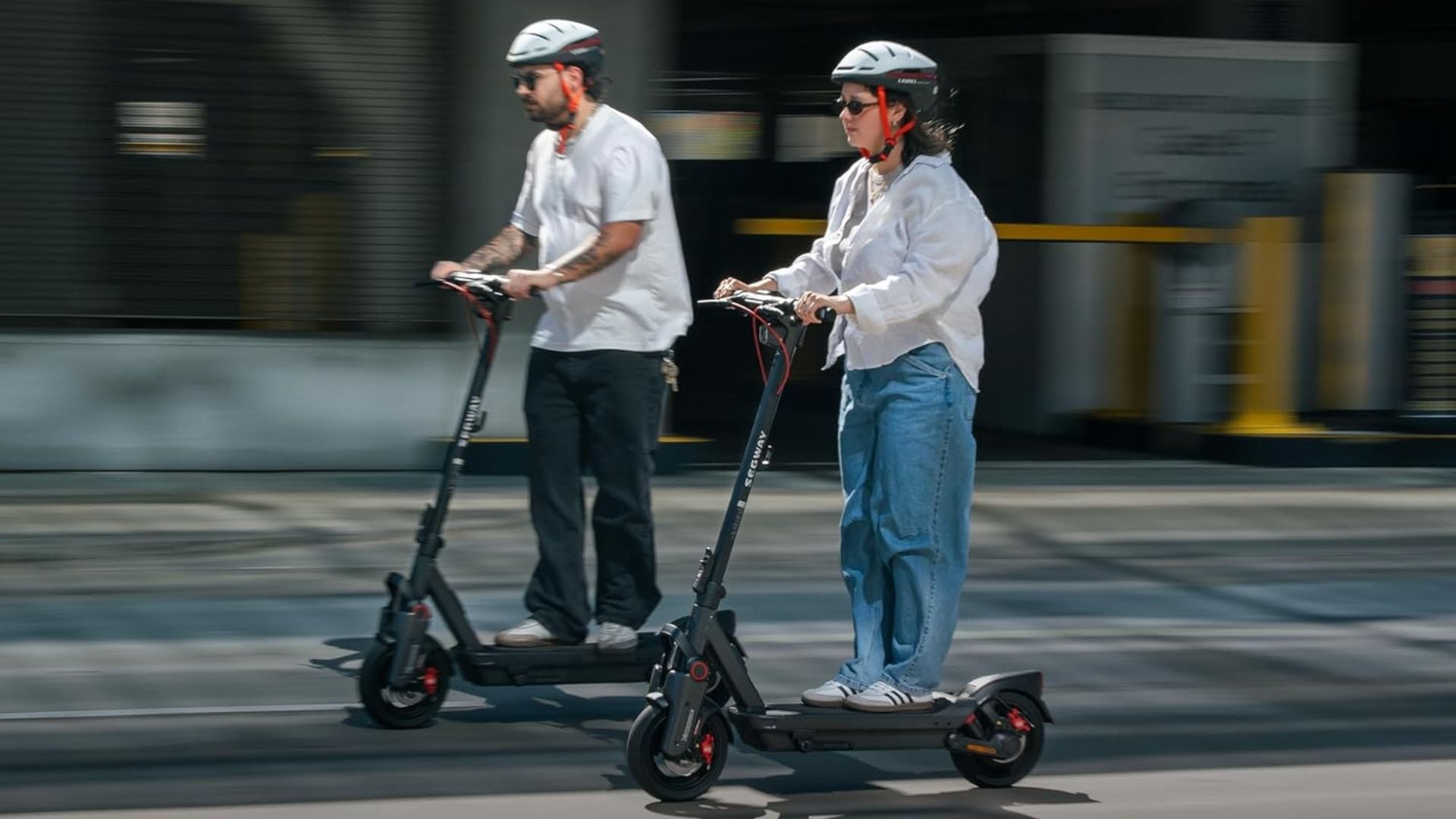 Two people riding Segway electric scooters.