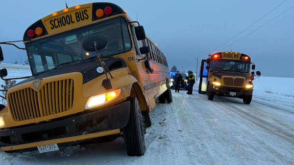 School bus with students on board slides into ditch