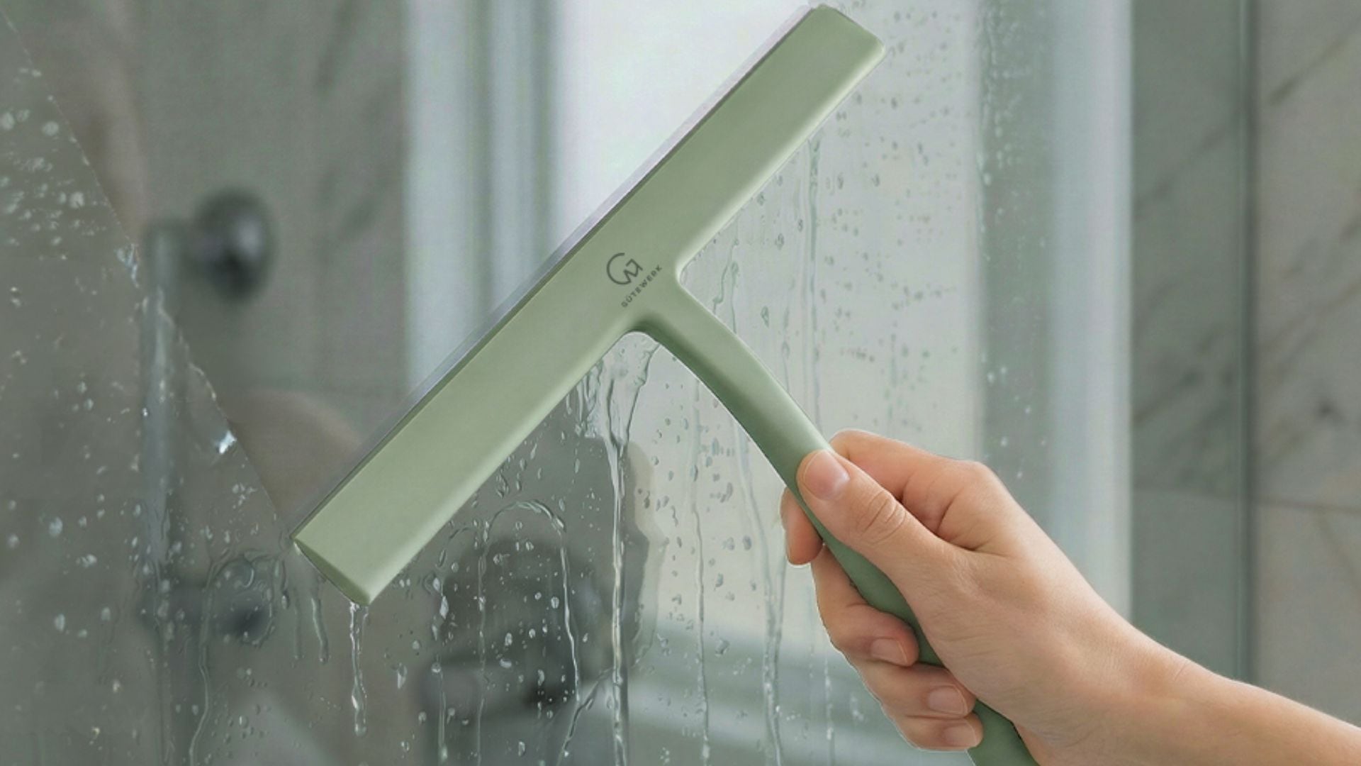 a person using a squeegee on a glass shower