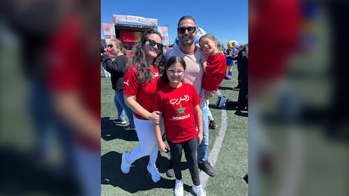 A family wearing red poses for a photo.