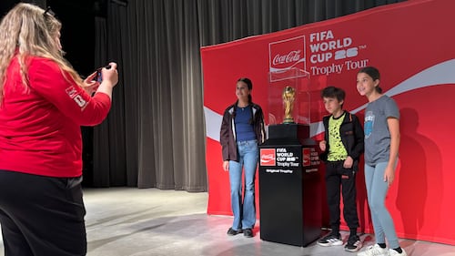 Fans pose with the FIFA World Cup Trophy.