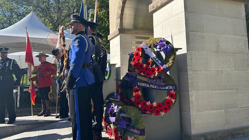 Military personnel stand at a monument.
