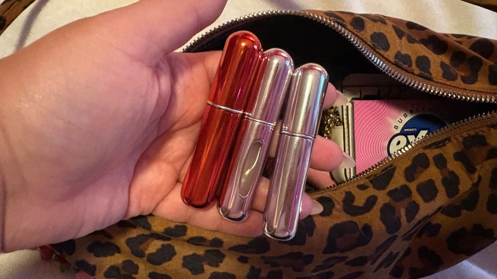 Bianca holding three of the atomizers over her purse